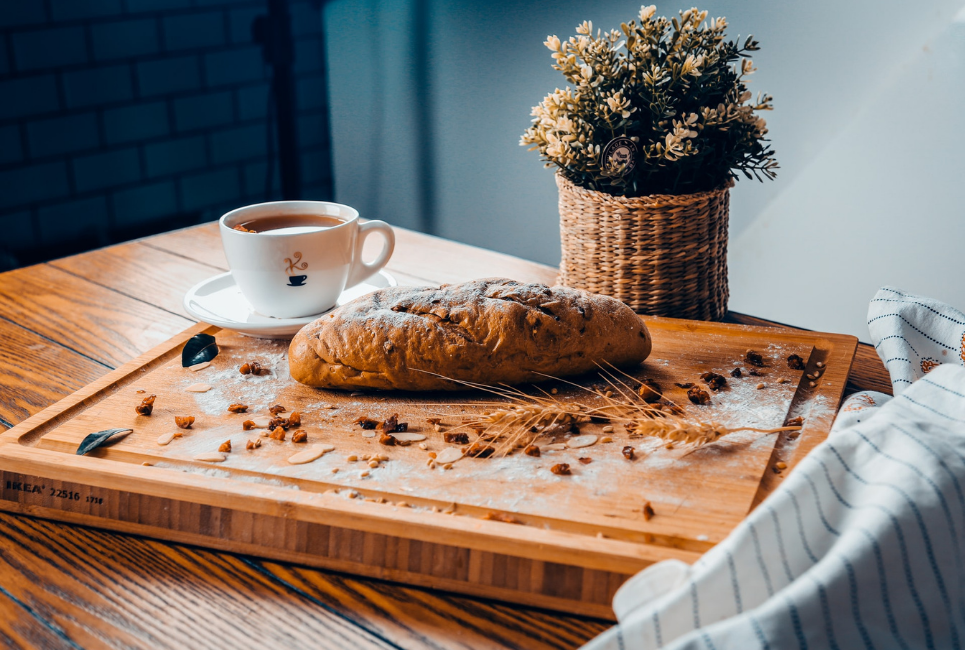 bread and hot mug on well decorated kitchen cutting board