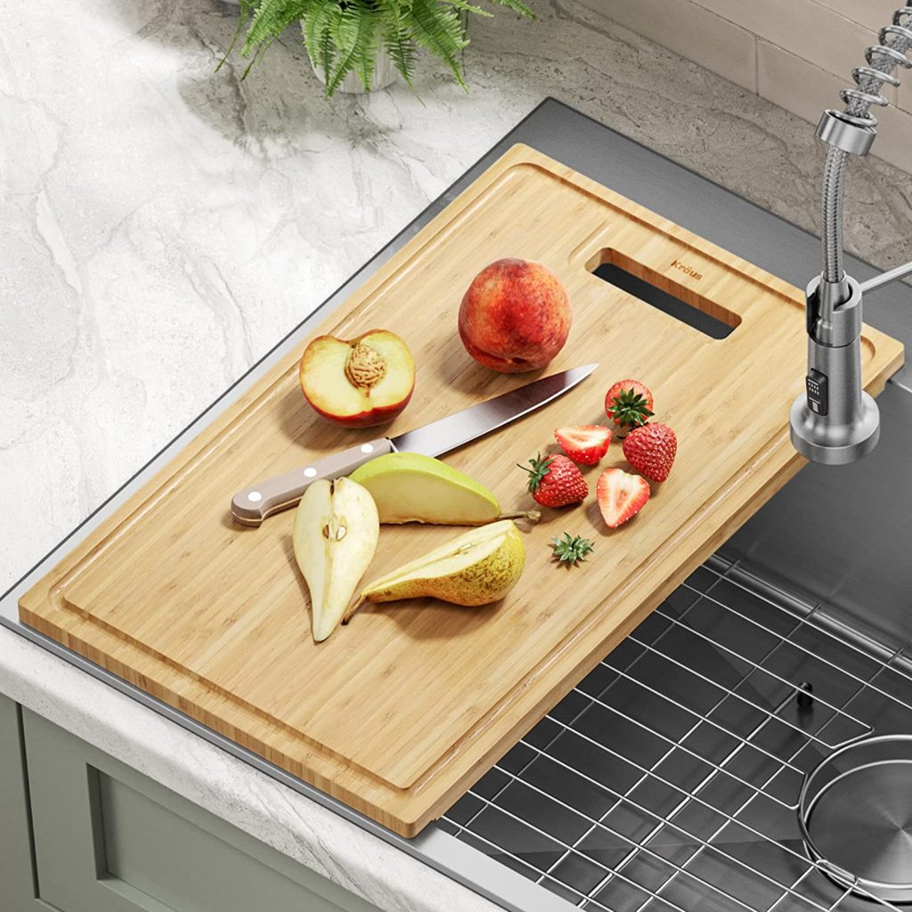 kraus cutting board fitting over a sink drain with fruit on top