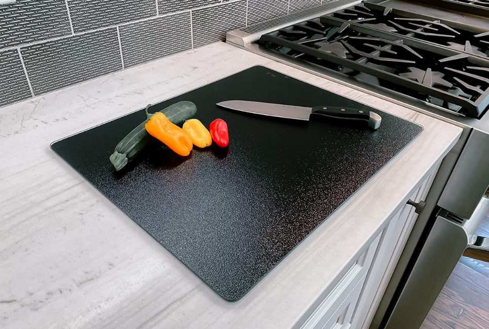 knife ang vegetables on black cutting board