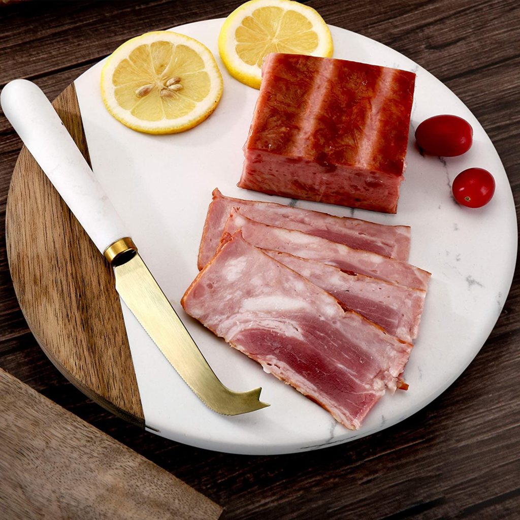 ham, lemon and knife on cutting board