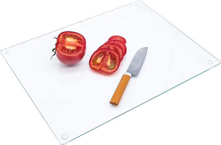 white cutting board with tomato and knife on it