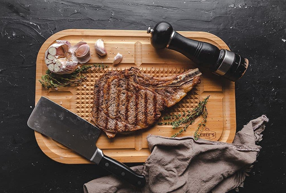 cutting board with steak pepper and garlic