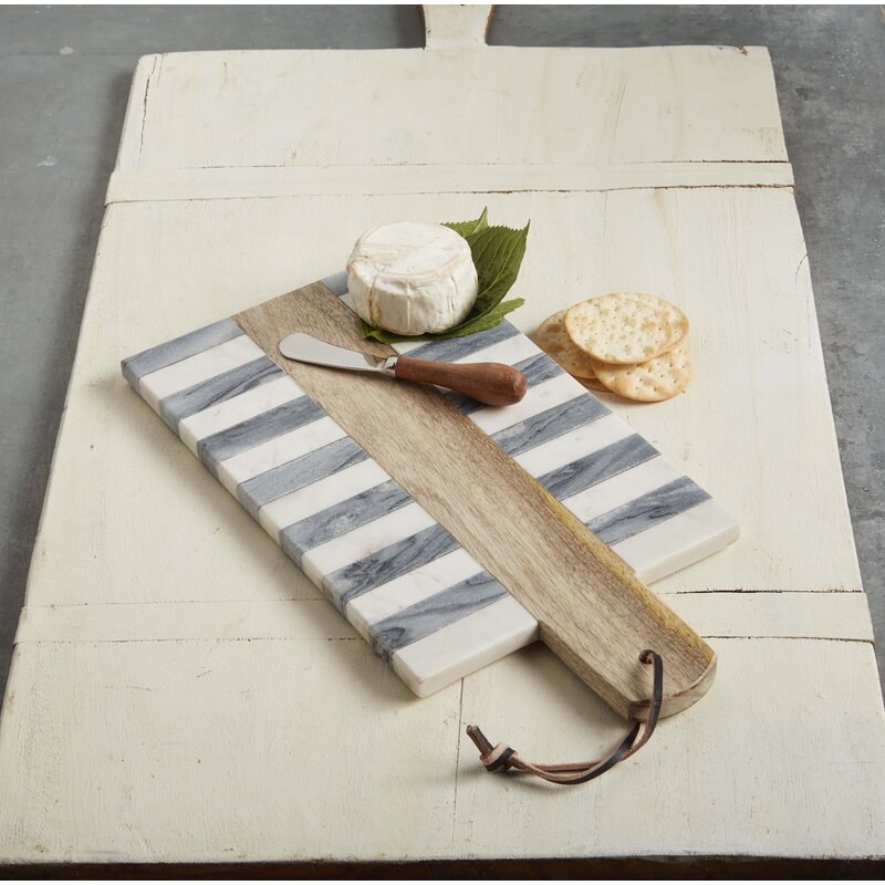 large cutting board with crackers, cheese and knife on board