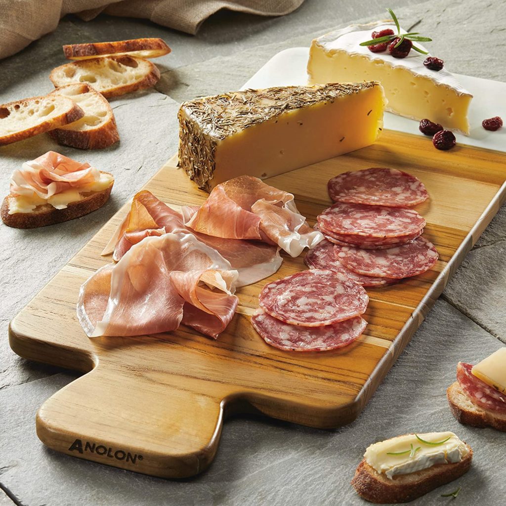 cutting board with meats and cheese on top of it