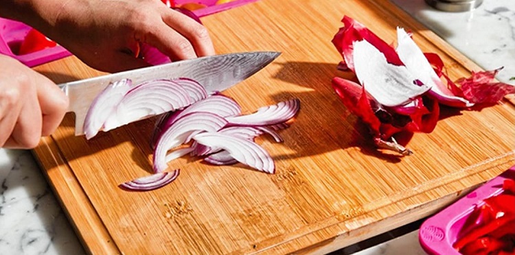 cutting board with sliced onions and knife