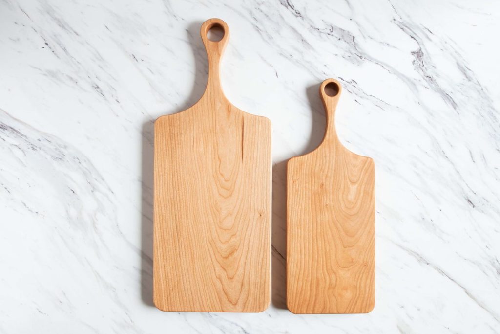 two cutting boards beside each other on marble countertop