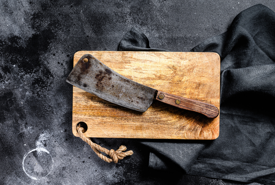 rustyed meat cleaver on butcher block cutting board