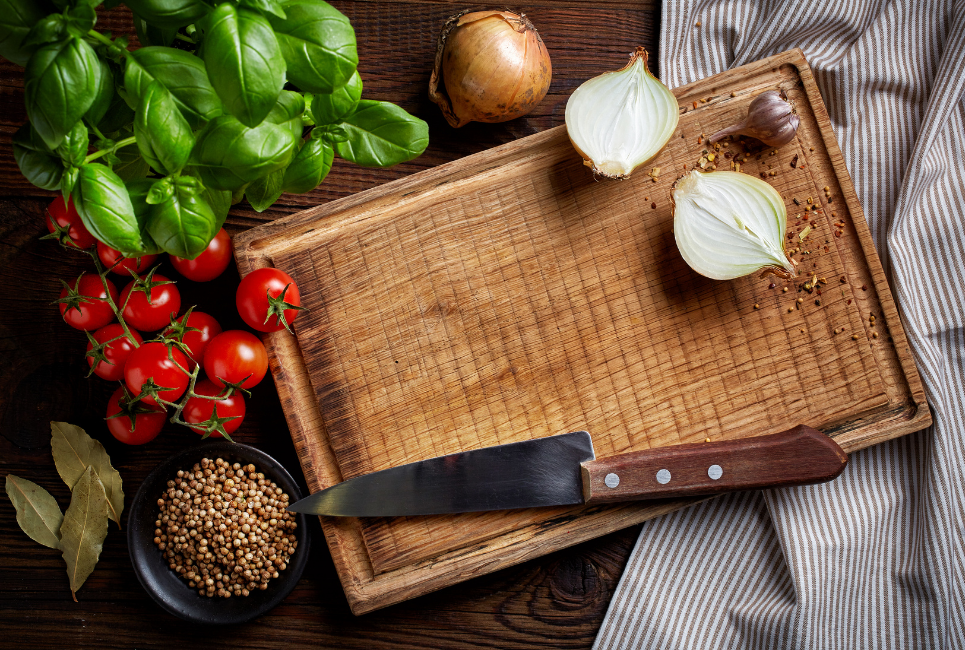 hickory cutting board with vegetables scattered around