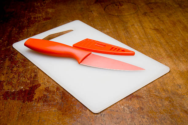 Orange knife on white cutting board