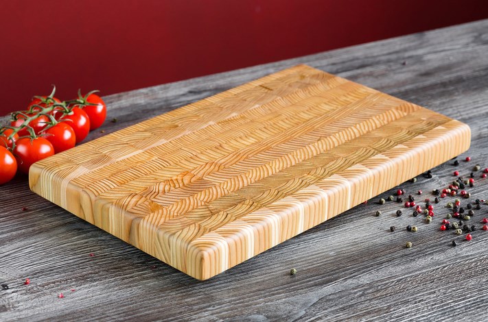cutting board on kitchen table with tomatoes beside it