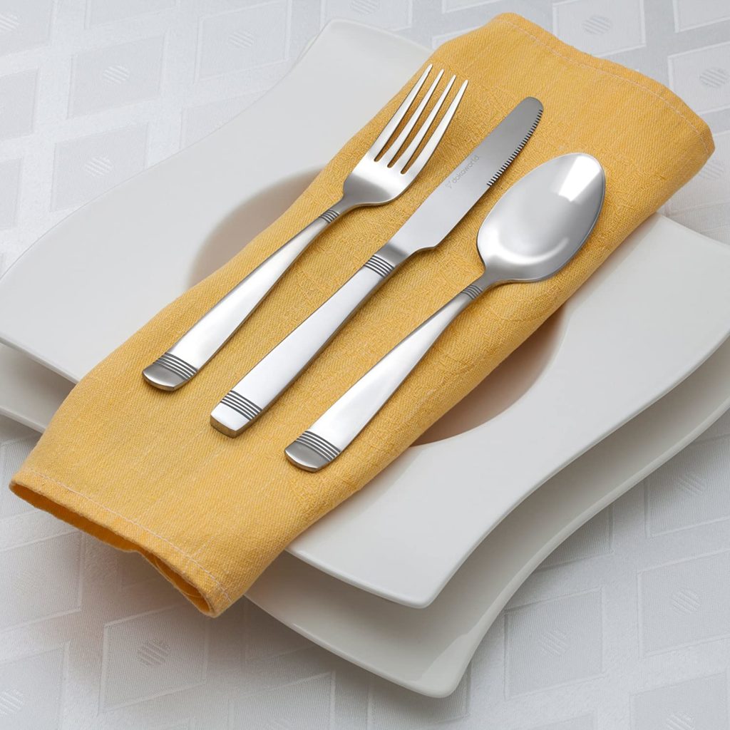 set of silver untensils on yellow napkin
