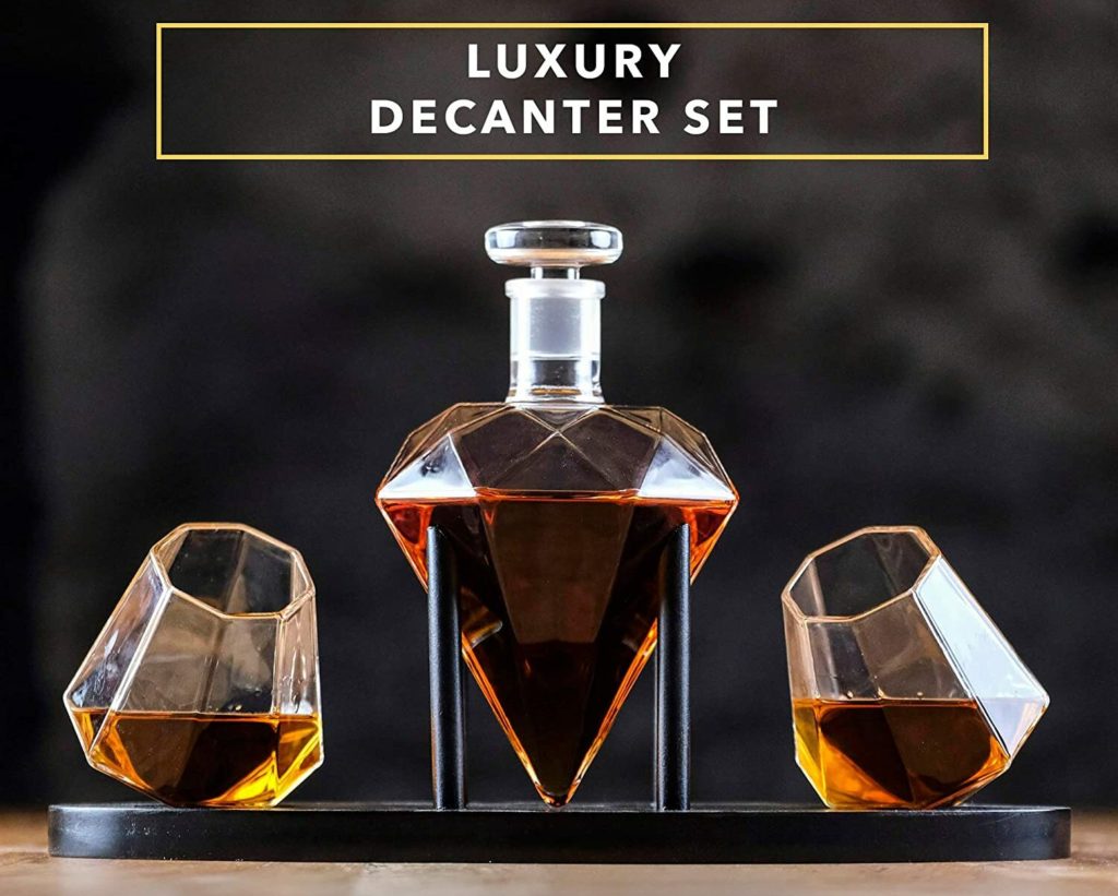 luxury whiskey decanter on black stand with tilted glasses