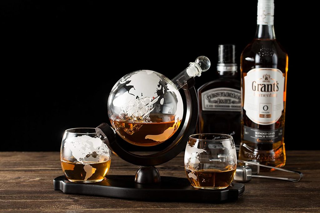 globe shaped decanter with bottles of whiskey and whiskey glasses
