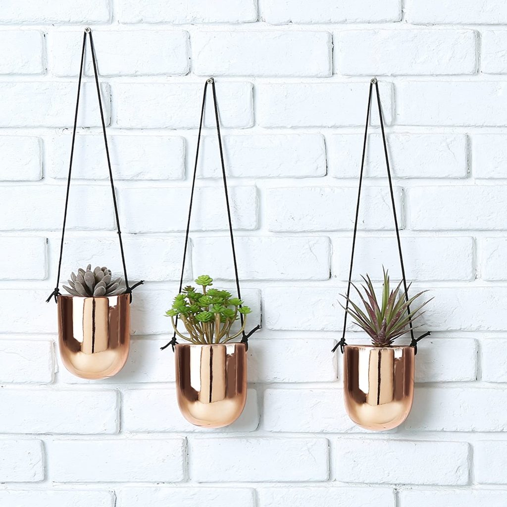 hanging decorative copper planters holding succulents