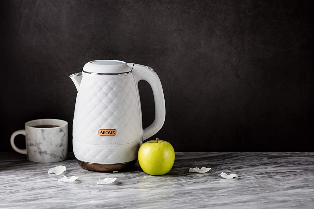 quilted design white eletric tea kettle with apple and mug on counter