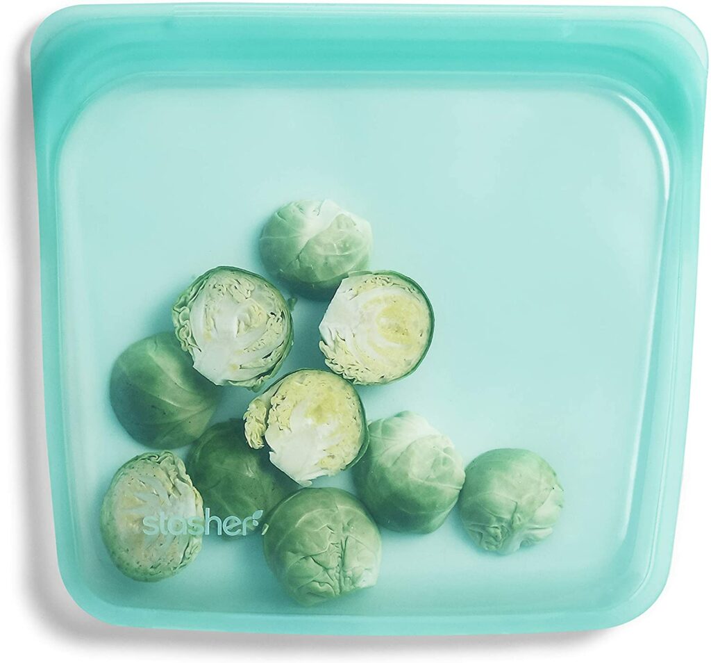 translucent teal reusable silicone bag filled with brussel sprouts