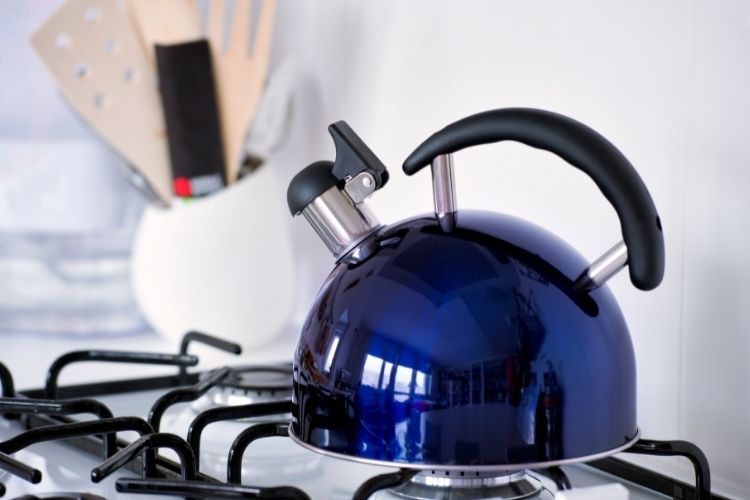 modern shiny dark blue tea kettle on stove