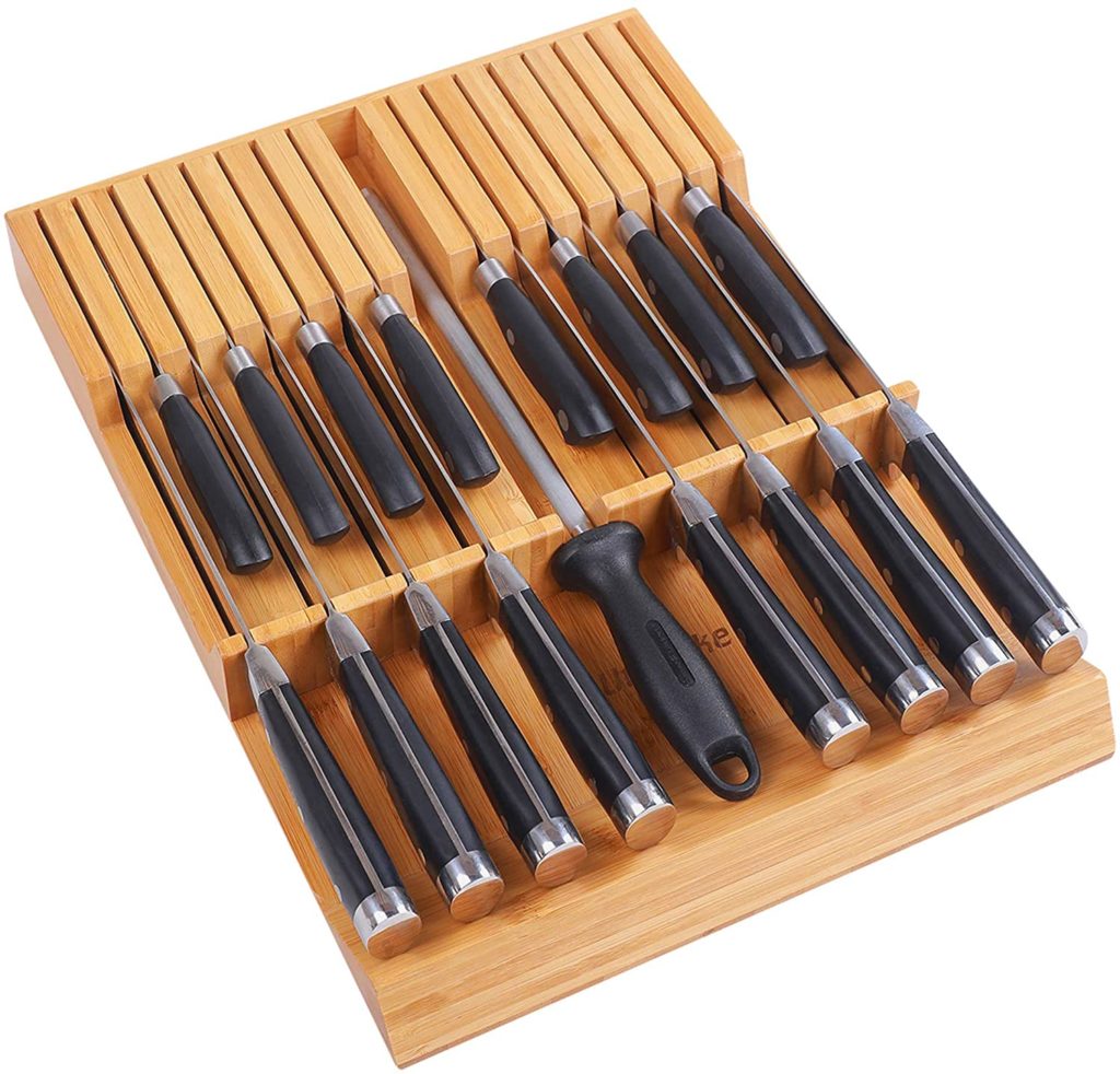 black handled knives and sharpener stored in bamboo holder