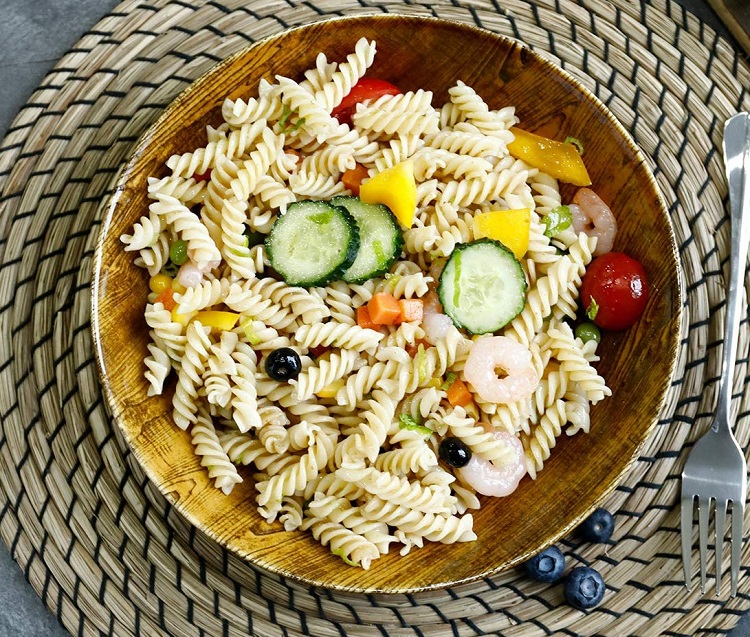 shrimp and cucumber pasta salad in wooden bowl