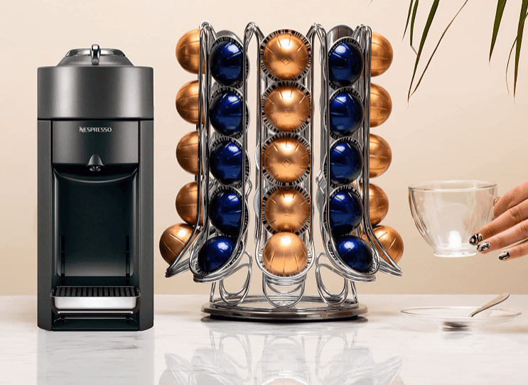 coffee station styled with cofee pod machine, coffee pod storage rag and womans hand holding mug