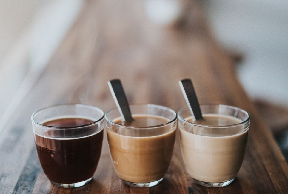 gradient of different color coffees in glass mugs lined up