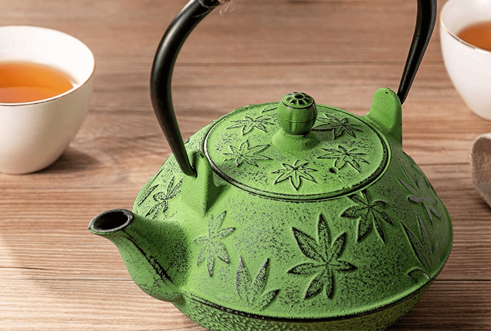 green cast iron teapot with botanical pattern