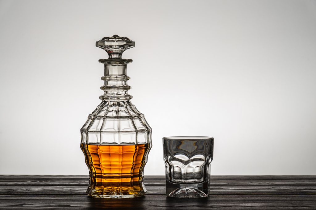 whiskey decanter with single empty whiskey glass