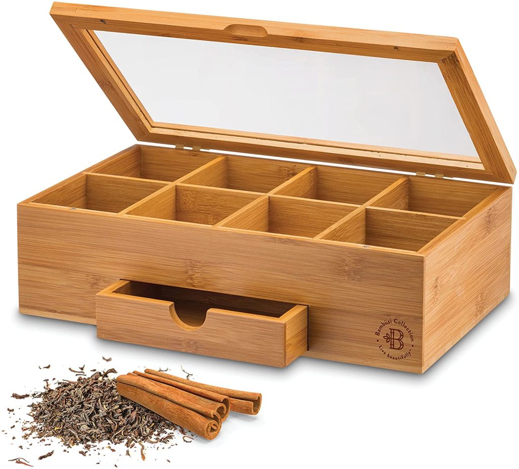 wooden tea box organizer with open lid and loose herbal tea in front