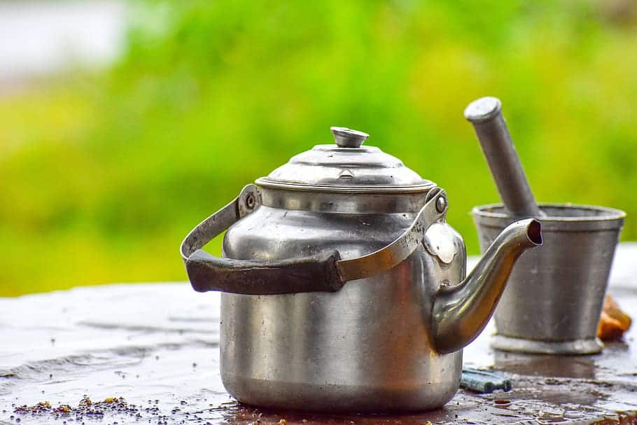 rustic metal tea kettle outdoor on tabletop