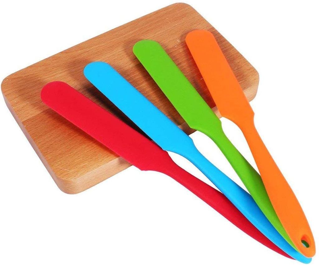 bright multicolored thin silicone spatulas and small wooden cutting board