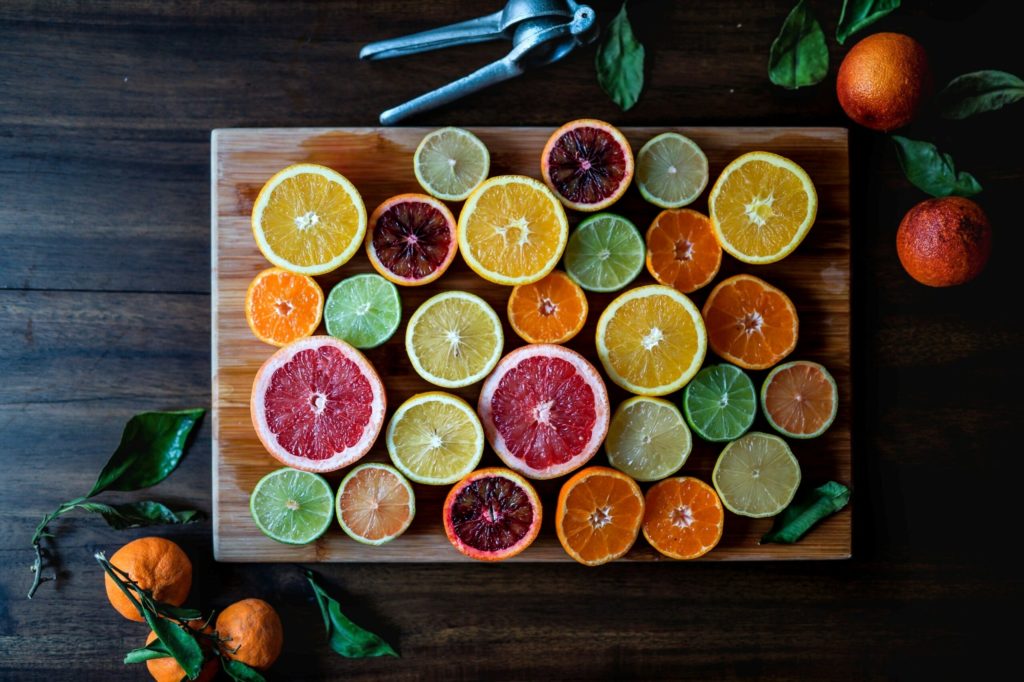 assorted citrus sliced and laid out on cutting board