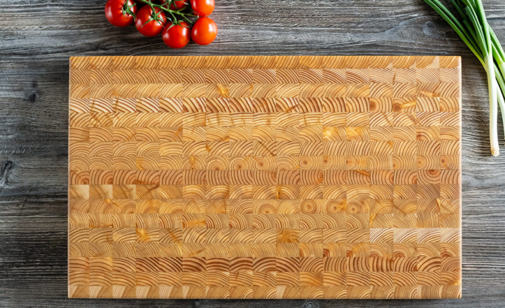 burl cutting board with tomatoes alongside it