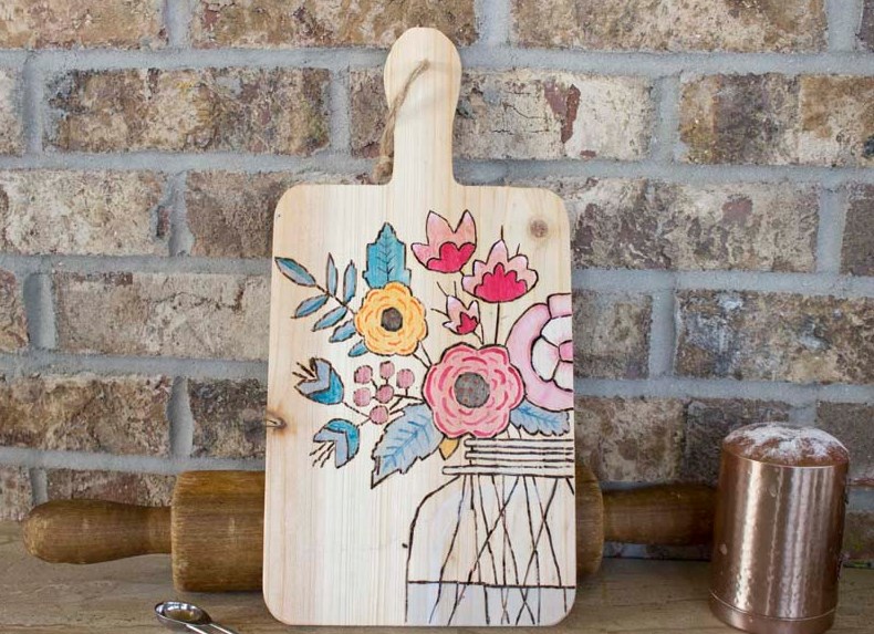 colorful floral design on wooden cutting board propped up in kitchen