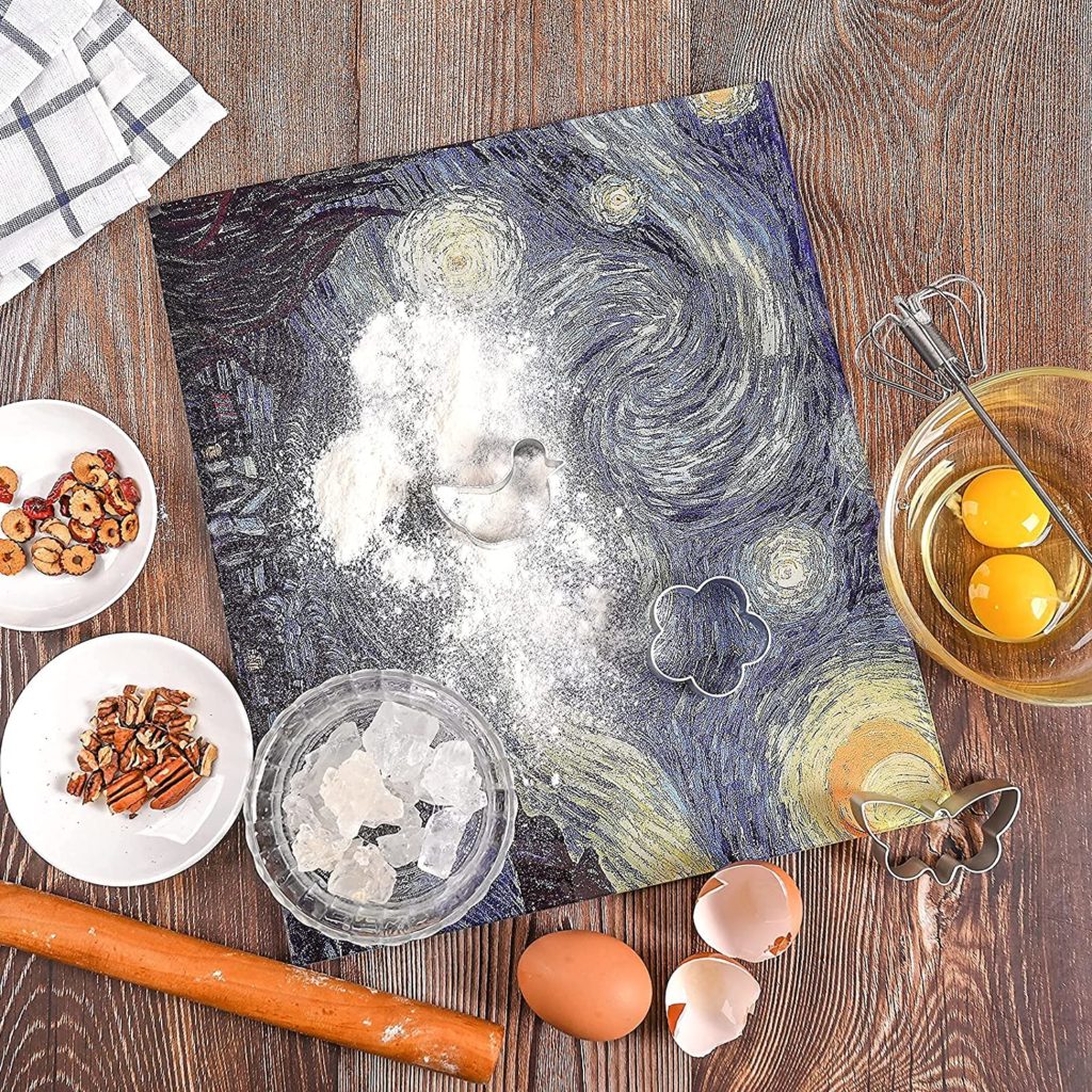 cookie cutters and baking supplies on starry night designed cutting board