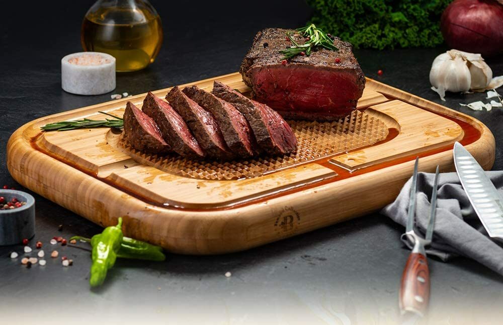 cut steak on textured cutting board with juice grooves