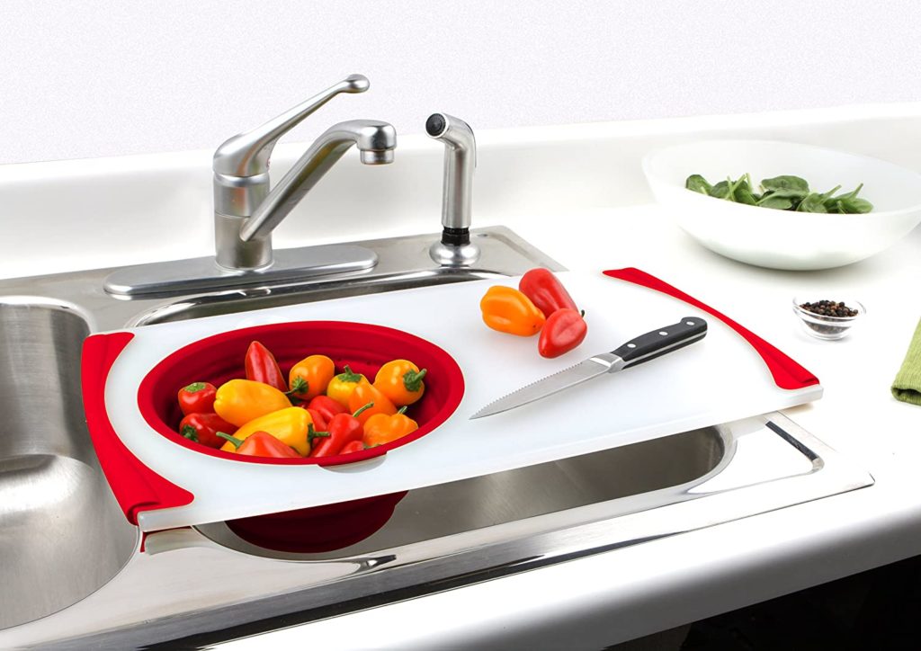cutting board with container over sink holding peppers