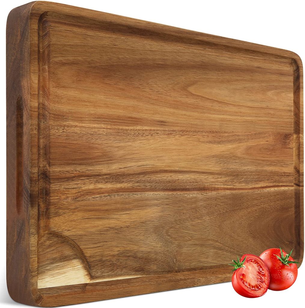 dark wooden cutting board with single tomato pictured
