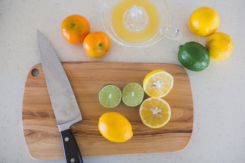 knife and cut citrus on small bamboo cutting board
