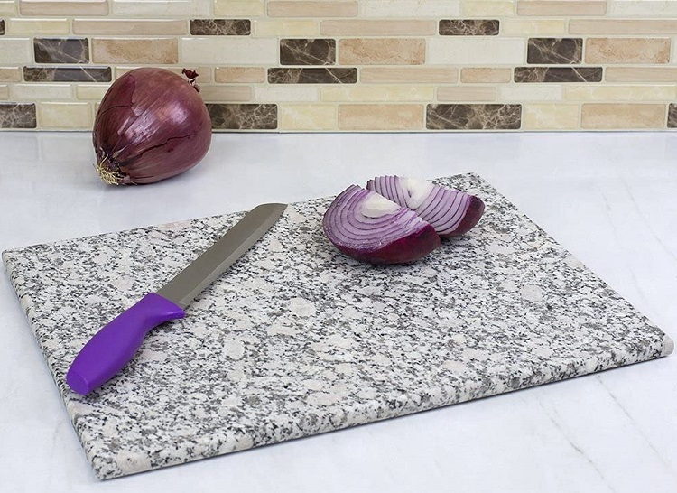 knife and red onion on stone cutting board