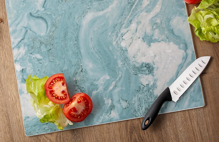 lettuce tomatoes and knife on blue and white quartz cutting board