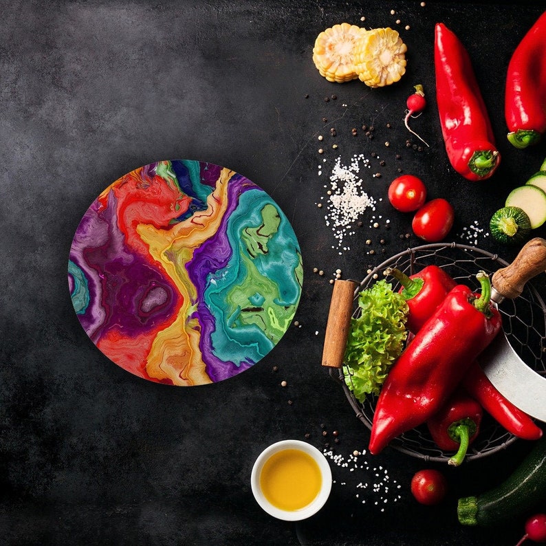 multicolored resin round cutting board surrounded by produce