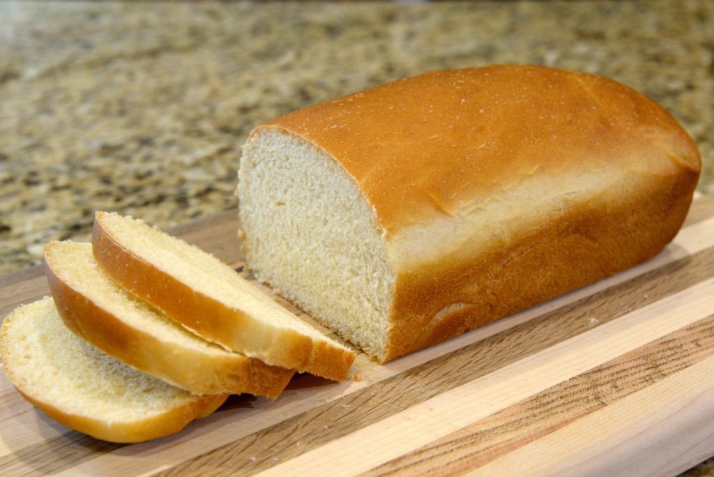 partially sliced loaf of white bread