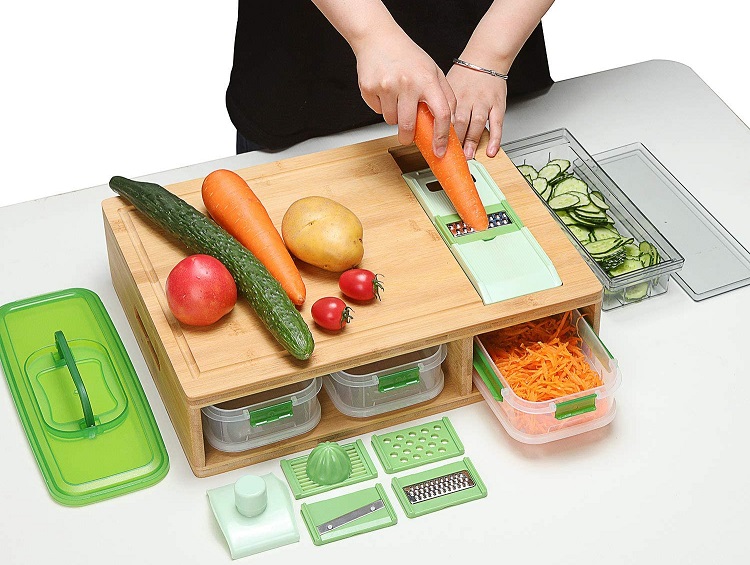 person using a food prep station with cutting board, grater and containers full of produce