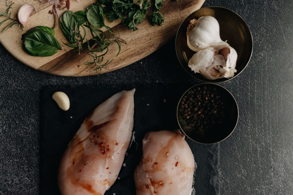 raw marinated chicken and ingredients on cutting board