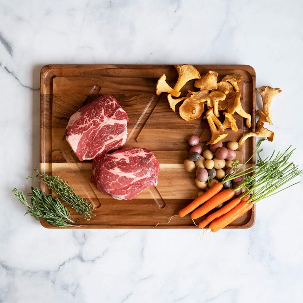 raw steak and vegetables on cutting board