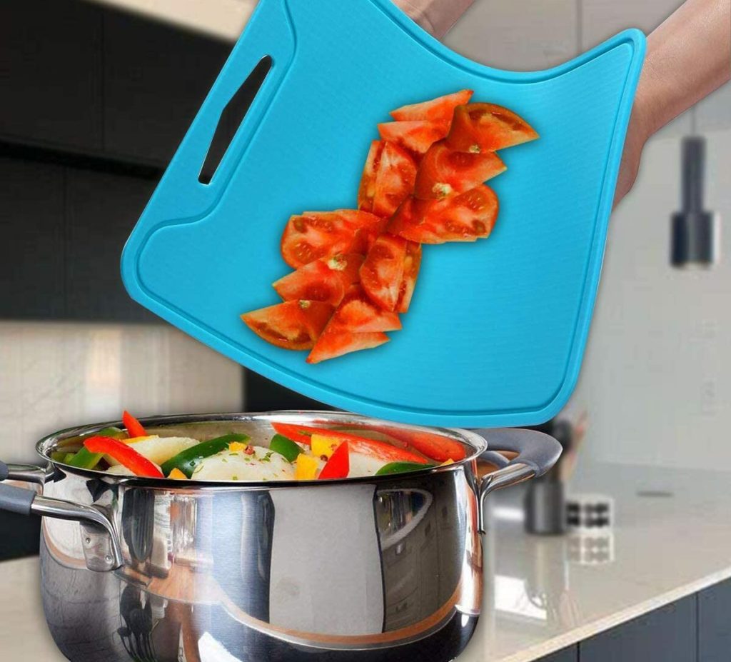 rendering of dropping sliced tomatoes into a pot from a flexible blue cutting board