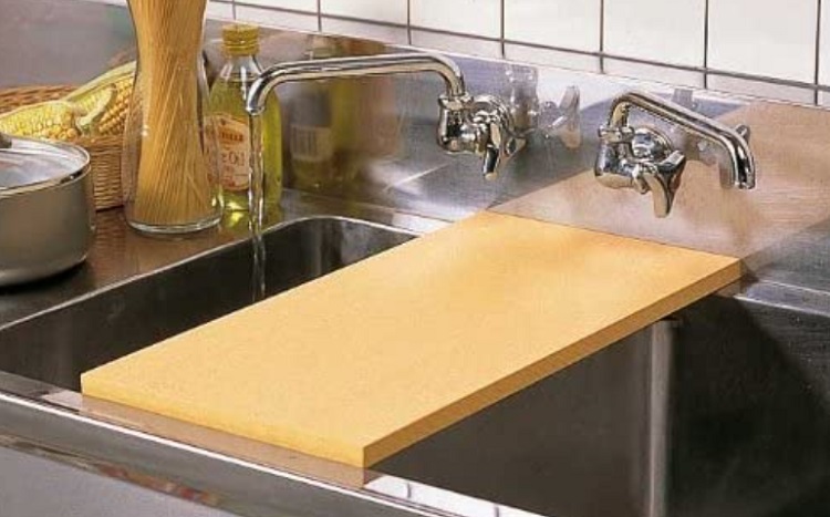 rubber cuttong board over sink with running water