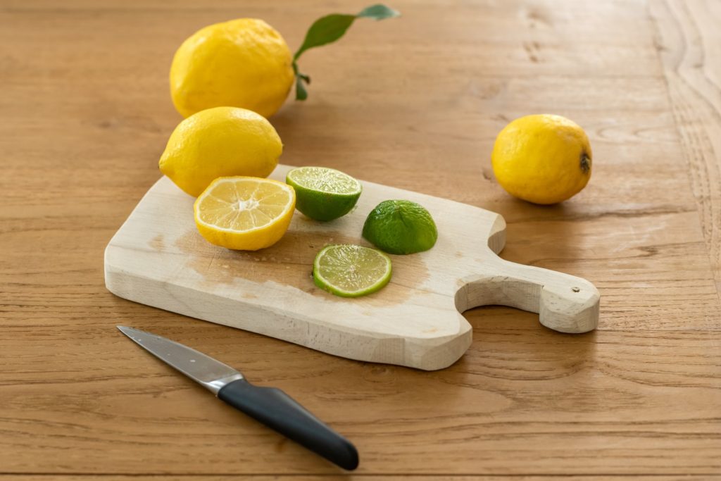small bamboo cutting board with sliced citrus and knife
