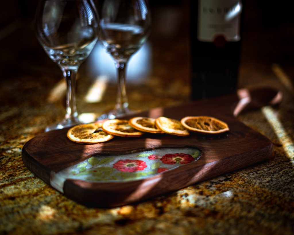 small maple cutting board surrounded by wine glasses