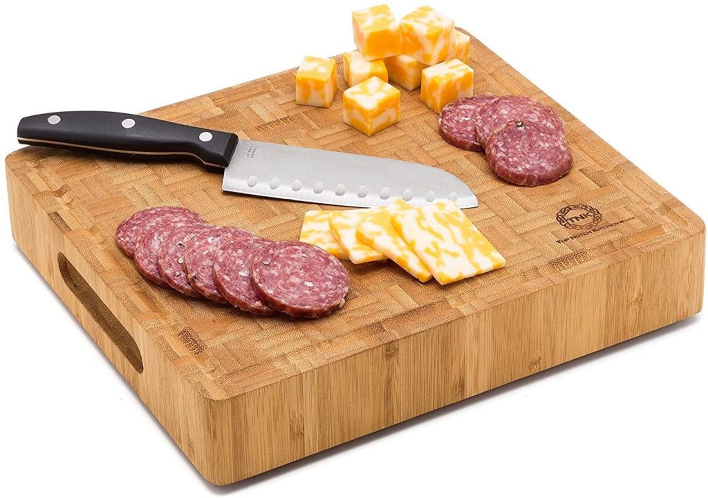 thick end grain cutting board with cheese and meat on it